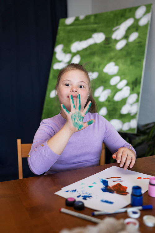 girl with down syndrome doing painting